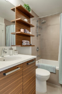 Main bathroom with natural wood vanity and matching wood open shelfs