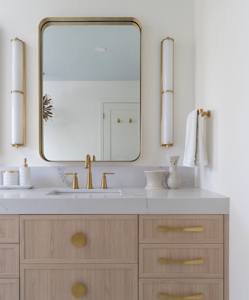 A modern bathroom with gold fixtures.
