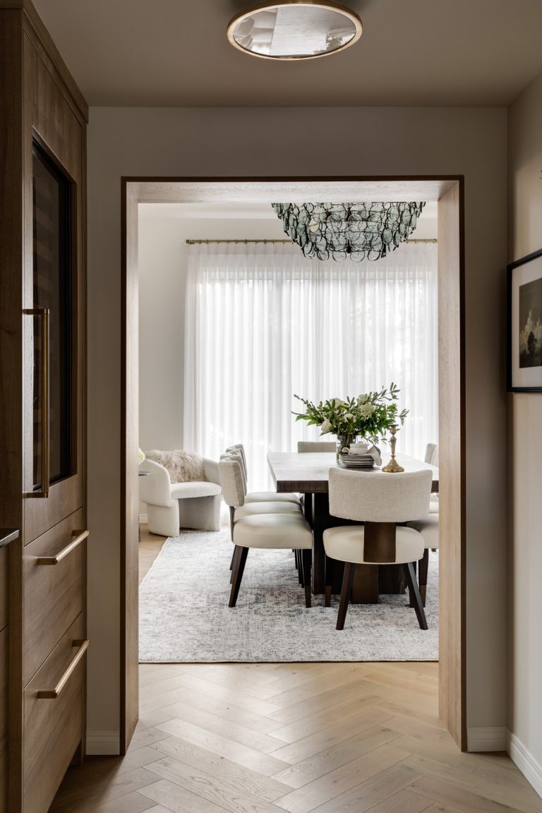 View of a dining room through a hallway in a newly renovated home.