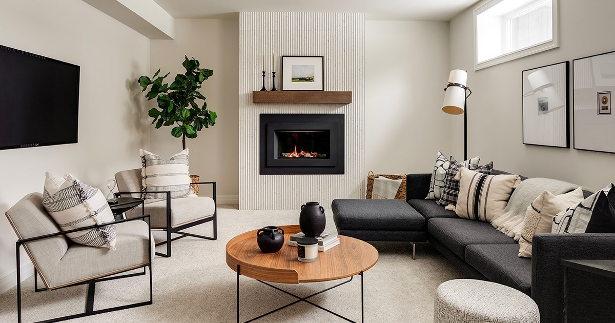 A newly designed basement with a fluted fireplace and modern furnishings