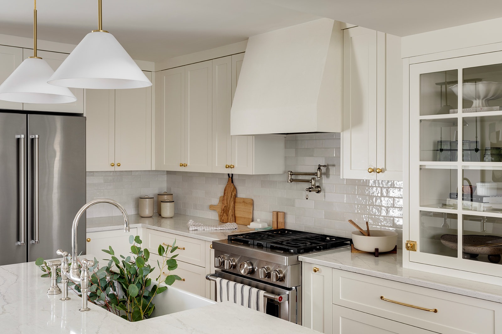 Modern condo kitchen with off-white cabinets and granite island.